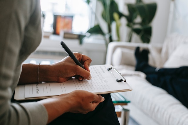 Psychologist writing on paper during a session.