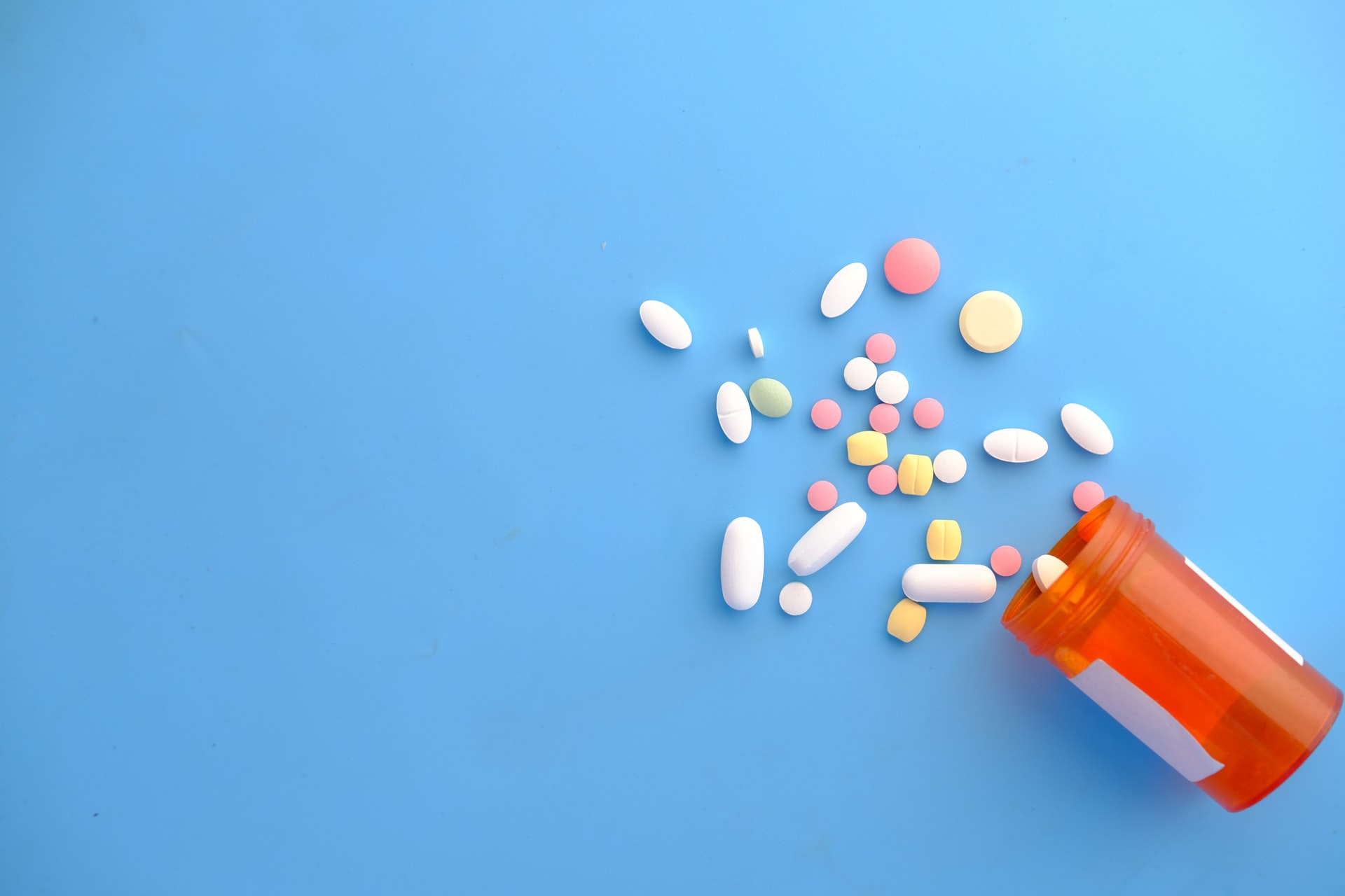 Pills spilled out of the bottle as a visual representation of alternatives to pain medication for chronic pain relief