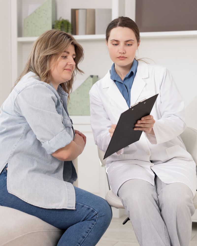 a doctor sits with a patient to explain treatment. all in solutions